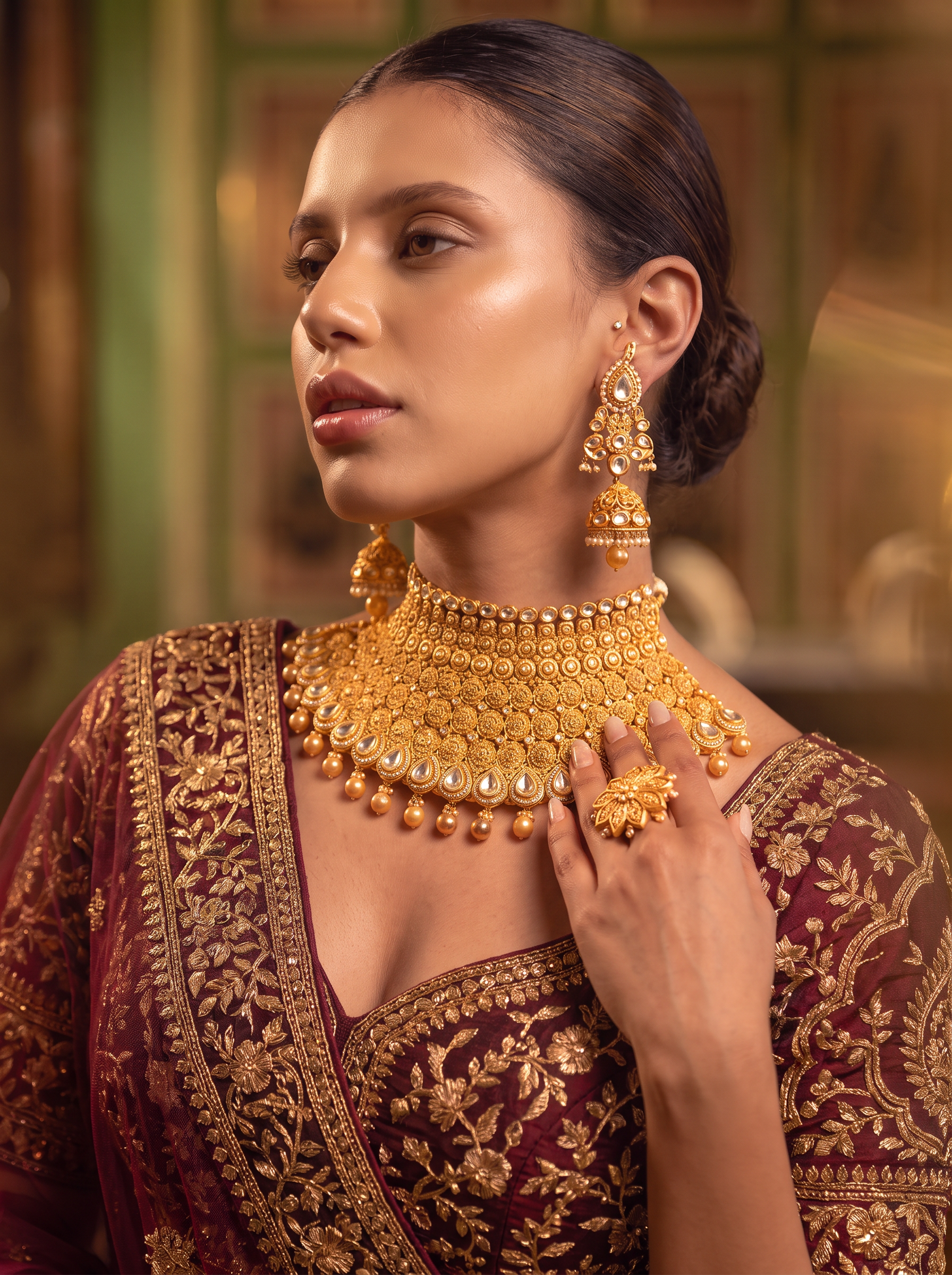 Gold bridal jewellery in burgundy editorial portrait